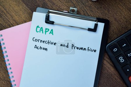 Foto de Concepto de CAPA - Acción correctiva y preventiva escribir sobre el papeleo aislado en la mesa de madera. - Imagen libre de derechos