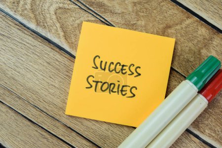 Photo for Concept of Success Stories write on sticky notes isolated on Wooden Table. - Royalty Free Image