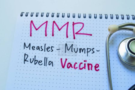 Photo for Concept of MMR - Measles Mumps Rubella Vaccine write on book with stethoscope isolated on white background. - Royalty Free Image