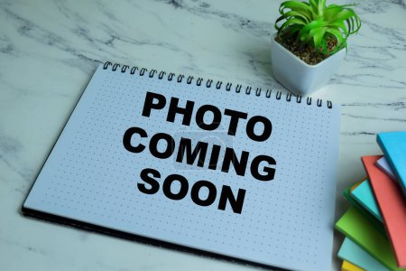 Photo for Concept of Photo Coming Soon write on book isolated on Wooden Table. - Royalty Free Image