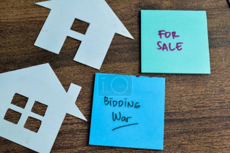 Téléchargez les photos : Concept de guerre d'enchère et à vendre écrire sur des notes collantes isolées sur la table en bois. - en image libre de droit