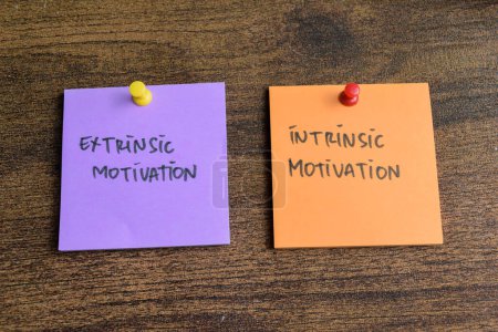 Photo for Concept of Extrinsic Motivation or Intrinsic Motivation write on sticky notes isolated on Wooden Table. - Royalty Free Image