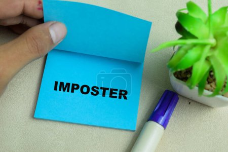 Concept of Imposter write on sticky notes isolated on Wooden Table.