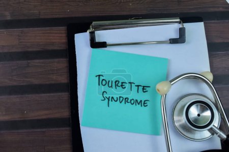 Konzept des Tourette-Syndroms schreiben auf klebrige Zettel mit Stethoskop isoliert auf Holztisch.