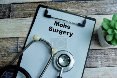 Concept of Mohs Surgery write on paperwork with stethoscope isolated on wooden background.