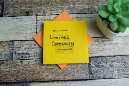 Concept of Limited Company write on sticky notes isolated on Wooden Table.