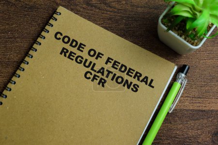 Konzept des Kodex der Bundesvorschriften CFR schreiben auf Buch isoliert auf Holztisch.