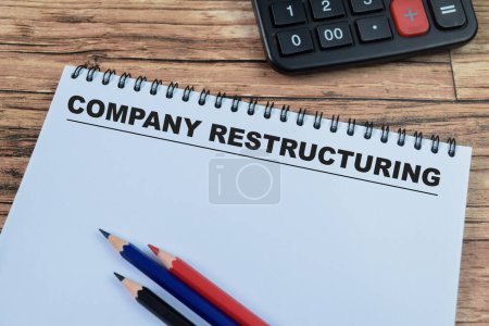 Concept of Company Restructuring write on book isolated on Wooden Table.