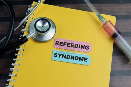 Konzept des Refeed-Syndroms schreiben auf klebrige Notizen mit Stethoskop isoliert auf Holztisch.