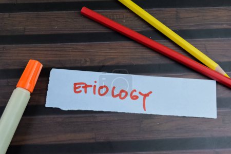 Concept of Etiology write on sticky notes isolated on Wooden Table.