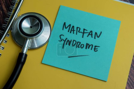 Konzept des Marfan-Syndroms schreiben auf klebrige Notizen mit Stethoskop isoliert auf Holztisch.