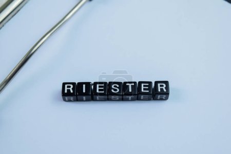 Concepto de Riester escrito en bloques de madera. Imagen procesada cruzada sobre fondo de madera