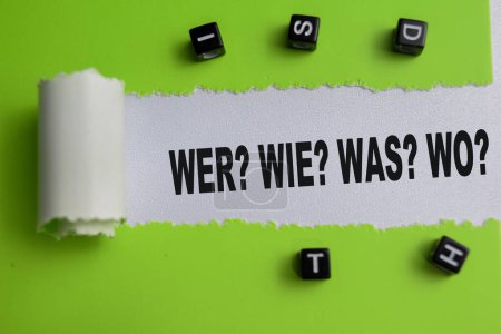 Concept of Wer? Wie? Was? Wo? Text written in torn paper.