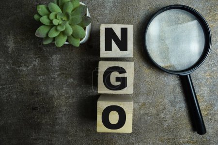 Concept of The wooden Cubes with the word NGO - Non-Governmental Organization on wooden background.