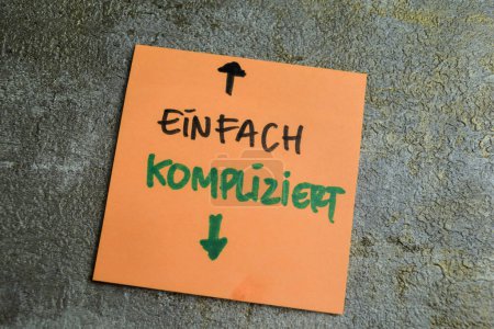 Concepto de aprendizaje de la lengua - Alemán. Einfach Kompliziert significa simplemente complicado escrito en notas adhesivas. Idioma alemán aislado en la mesa de madera.
