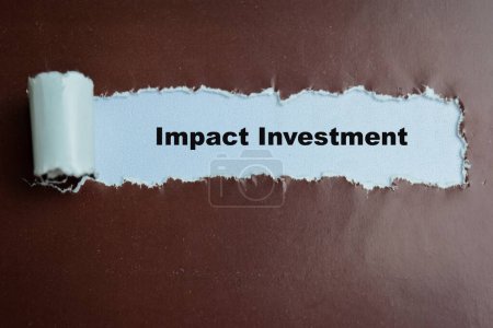 Concepto de Impacto Inversión Texto escrito en papel roto.