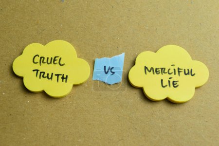 Concept of Cruel Truth vs Merciful Lie write on sticky notes isolated on Wooden Table.