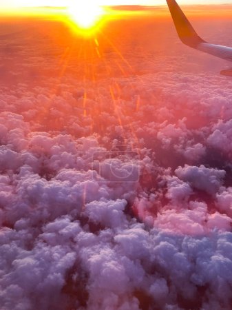 Téléchargez les photos : Gros plan de nuages vus depuis un avion. Nuages cumulonimbus au coucher ou au lever du soleil avec la silhouette d'une aile d'avion. - en image libre de droit