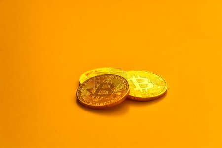 Foto de Tres frijoles bitcoin amarillos colocados en superficie plana. - Imagen libre de derechos