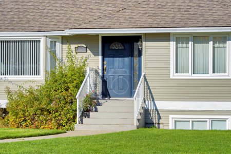 Foto de Entrada de casa residencial con césped verde en frente. Casa familiar en día soleado brillante en Vancouver, BC - Imagen libre de derechos