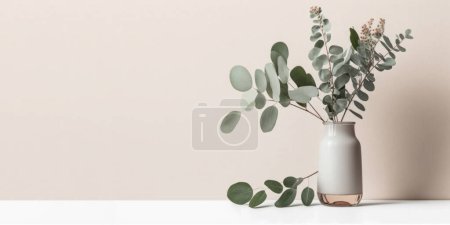 Téléchargez les photos : Belle fleur d'eucalyptus dans un vase en céramique sur table avec fond blanc. Espace de copie. - en image libre de droit