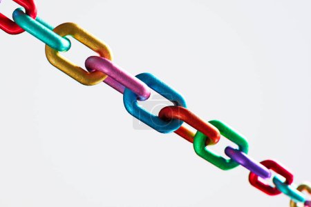 Foto de Una cadena metálica fuerte y vibrante de varios colores, que representa los valores de cooperación, unión, diversidad, variación y trabajo en equipo. Esta cadena colorida es un símbolo de fuerza y unidad. - Imagen libre de derechos