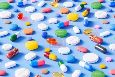 Photo for Countless multi-colored pills, capsules, and tablets are scattered on a light blue background. This photo is perfect for use in medicine, pharmacy, or healthcare topics. - Royalty Free Image