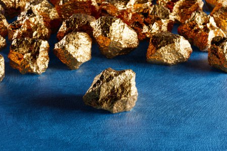 Photo for A group of pure shiny gold pieces on the rough background. Expensive noble metal. Golden nuggets. Gold ore. Symbol of wealth. Precious treasure. Concept of investing capital, finance, banking purpose. - Royalty Free Image
