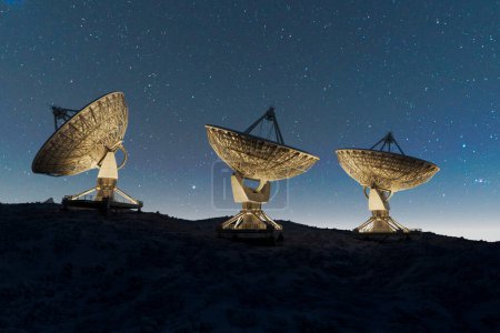 Satellite dishes on the top of the hill at night. Space observatory signal search. Radio astronomy observatory. Amazing night sky landscape with antenna silhouettes. Discovery, science, technology.