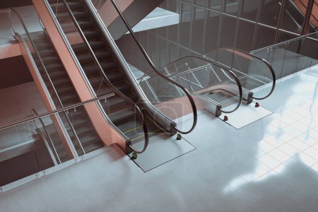 Photo for Modern escalators made of glass and steel. Stairway. A piece of urban architecture in business building, station, mall, or shopping centre. Passage. Way of transportation - Royalty Free Image