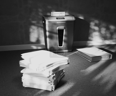 Photo for The page is inserted into machine. It shreds and slowly falls into container. A camera slowly rotates following paper piece which is shredded. Slow motion. Trash recycling. Environment protection. - Royalty Free Image
