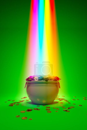 Photo for The magical rainbow that leads to the pot of gold. Irish symbol of luck, success and wealth. A green cauldron is full of golden coins. Leprechaun's treasure on a green background. St Patrick day. Rich - Royalty Free Image