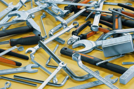 Lots of workshop tools are spread over the yellow surface. Hammers, screwdrivers, wrenches, spanners, pincers, torx and hex keys. Renovations. Mechanical maintenance. Toolbox essentials.