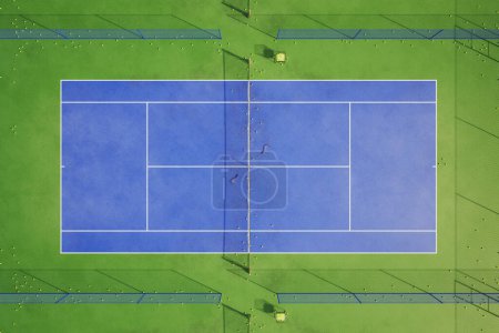 Foto de La perspectiva del ojo de pájaro muestra el área azul de la cancha de tenis. Un lugar que proporciona el escenario perfecto para un partido amistoso o un partido competitivo. La red, 2 raquetas de tenis y un montón de bolas amarillas. - Imagen libre de derechos