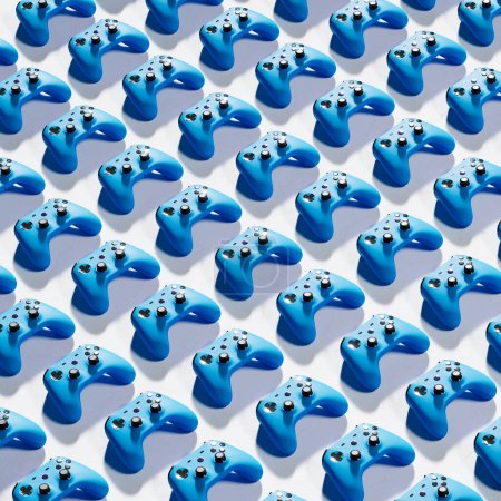 Foto de La imagen de un sinfín de controladores de juegos azules dispuestos cuidadosamente en un patrón de cuadrícula sobre un fondo blanco. Perfecto para ilustrar juegos, tecnología y conceptos de entretenimiento - Imagen libre de derechos
