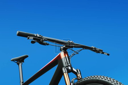 Ein Bild vom Lenker eines MTB-Fahrrads. Präsentiert den vorderen Teil des Rahmens, Griffe, Bremshebel mit Seilen, Federmechanismus und den Sattel. Detaillierte Fahrradkomponenten für Online-Shops