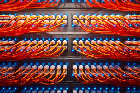 Foto de Innumerables cables naranja en un moderno gabinete de servidores en una granja de renderizado oscuro iluminado por un solo foco. Cables etéreos coloridos organizados. Animación de bucle sin fin, sin fisuras. Vista superior. - Imagen libre de derechos