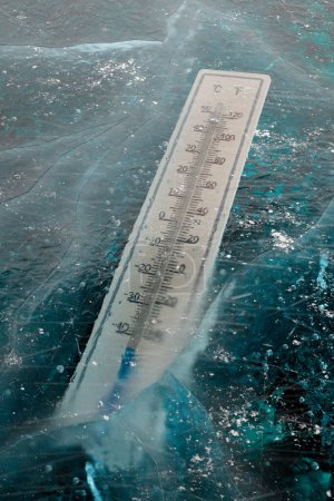 Photo for The thermometer trapped in the thick ice in winter surrounding. The mercury column showing extremely low temperature. Freezing cold. Wheater measurements. Wintertime. It's cold outside. Snowy season. - Royalty Free Image