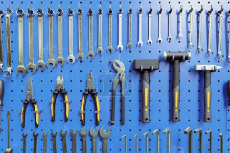 A picture of the various workshop tools on the workbench. Storage. Toolkit. Essentials. Blue panel. Equipment holder. Hammers, wrenches, spanners, pincers, torx and hex keys. Pegboard. Front view