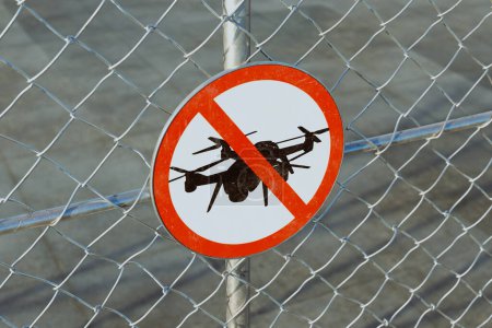 Ein Bild zeigt ein "No Drone" -Schild an einem Zaun um einen Flughafen, das als Warnung vor nicht autorisierten Luftfahrzeugen dient. Das Schild ist gut sichtbar und lesbar. Die Bedeutung der Sicherheit
