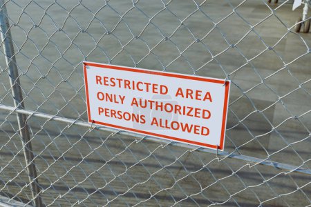 Photo for An image of a red stop sign on a fence at an airport, with restricted access to authorized personnel only. The red stop sign conveys a sense of danger and restricts entry to unauthorized persons - Royalty Free Image