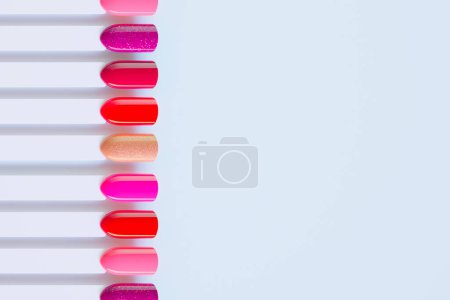 Photo for Nail polish swatches in different colors. Colorful manicure lacquer samples arranged on a light background. Multicolor vibrant set of false nails for beauty salon. Choice for the client. - Royalty Free Image