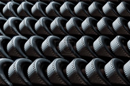 An endless and countless stack of new car tires in a vast warehouse. This image showcases the abundance of new tires that are ready to be used for transportation purposes