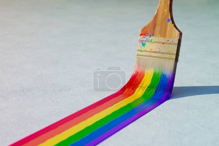 Photo for Wooden paintbrush leaving strokes of dense, colorful paint, Red, orange, yellow, green, and blue colors are symbolic of Lgbt social movements. A brush dipped in delightful and vibrant rainbow paint. - Royalty Free Image