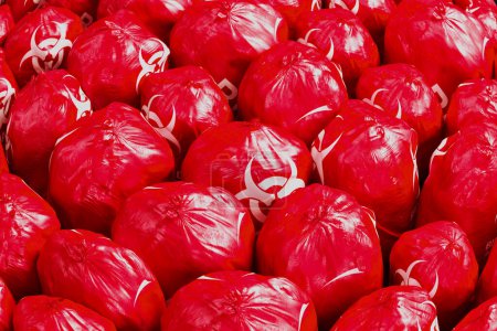Photo for Picture of the countless red biohazard trash bags full of dangerous waste. Medical, biomedical of infectious solid or non-sharp waste disposal. Waste storage in bright red bin plastic bags - Royalty Free Image