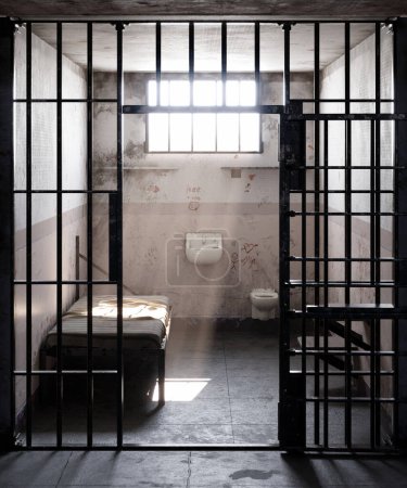 En una celda de prisión desolada, los rayos de luz solar atraviesan la ventana abierta, proyectando un cálido y radiante resplandor sobre la cama. Esta imagen captura la yuxtaposición de la libertad y el confinamiento.