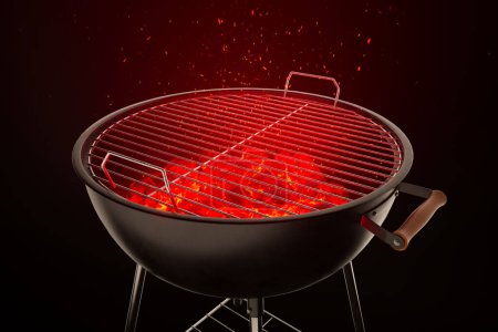 Photo for An empty grill with red very hot charcoal on dark background. Ready for grilling. Preparing a tasty meal. Cooking. Traditional American barbeque. Heat rising from the fire. Side view. - Royalty Free Image
