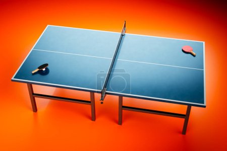 Téléchargez les photos : Une configuration professionnelle d'une table de ping-pong bleue debout dans une pièce vide au sol rouge vif. Des raquettes et une balle sont placées sur la table, prêtes à ce que les joueurs commencent un jeu - en image libre de droit