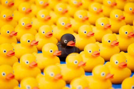 Téléchargez les photos : Photo de l'énorme armée de canards en caoutchouc. Jolis jouets jaunes disposés en rangées orientées dans une direction. Canetons en plastique prêts pour le plaisir de l'enfant dans le bain. Symbole de jeu dans l'eau pendant la baignade - en image libre de droit