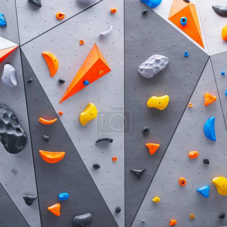 Ein Bild von der Kletter- oder Boulderwand. Rock extreme Sportaktivität für Indoor-Training und Bewegung in der Freizeit. Testen Sie Ihre Fähigkeiten, während Sie durch eine Vielzahl von Routen und Hindernissen navigieren.